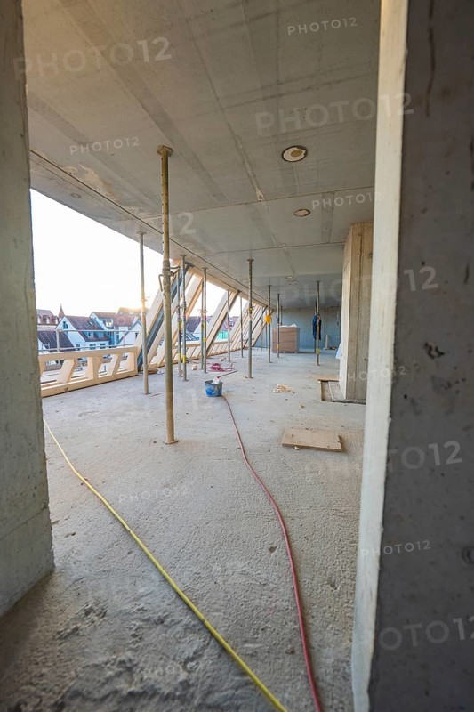 Open interior with construction work, exposed concrete walls and supports, carpentry construction site, roof extension, renovation, Stuttgart, Germany