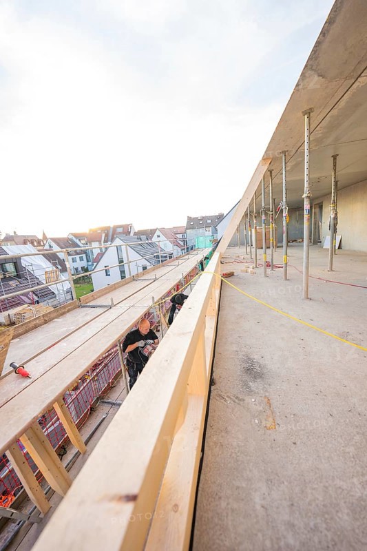 Worker on a construction site looking at residential buildings and the half-finished interior, carpentry construction, roof extension, renovation, Stuttgart, Germany
