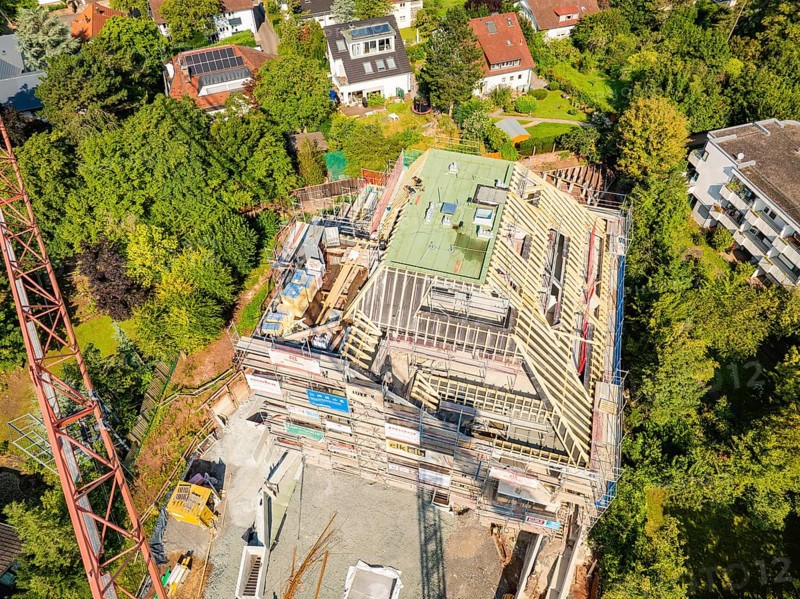 Roof of a house under construction with crane and surrounding houses in the countryside, construction site of a carpentry workshop, roof extension, renovation, Stuttgart, Germany