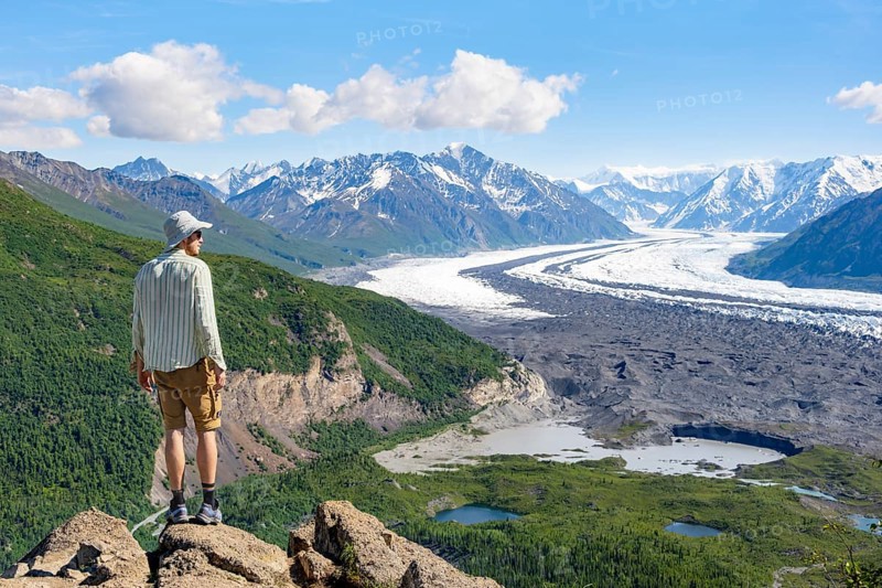 Young man enjoying the view, view of impressive mountain landscape with Matanuska glacier and glaciated mountain peaks, Lion's Head, Chugach Mountains, Alaska