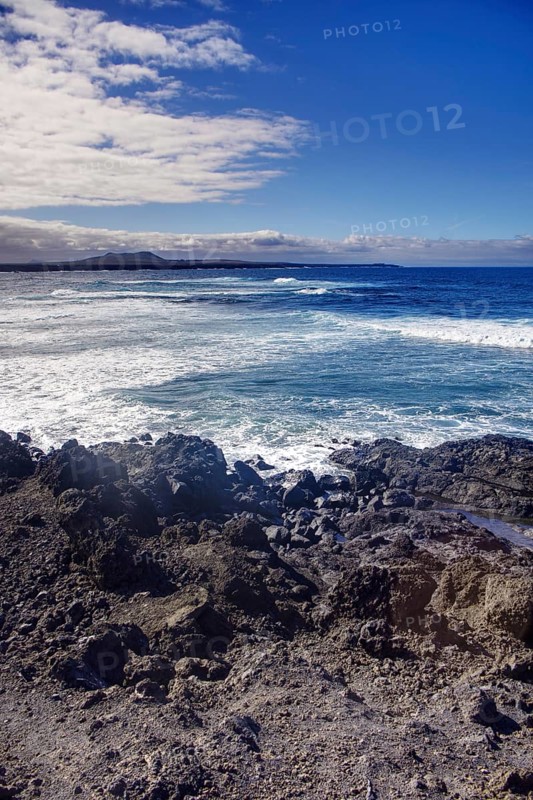 Rocky coast with big waves and wide horizons under clear skies, Playa del Janubio, Yaiza Lanzarote