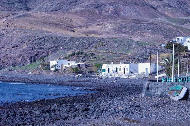 Small houses along a rocky coastline with a deep blue sea, Playa Quemada, Yaiza Lanzarote