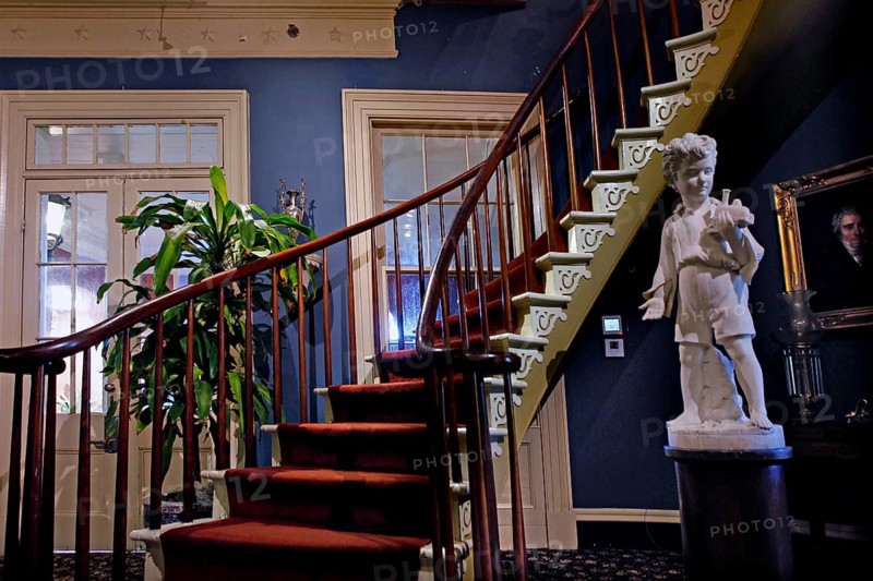 Elegant wooden staircase with sculpture in a historic interior, zero