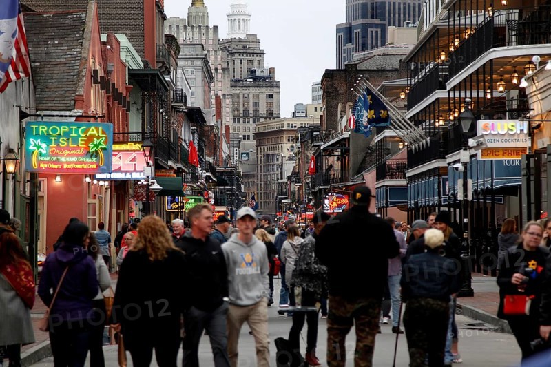 Bustling Bourbon Street at night with numerous passers-by and illuminated signs, New Orleans, Louisiana, USA