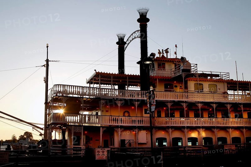 A paddle steamer on the River Front, illuminated at dusk in New Orleans, New Orleans, Louisiana, USA