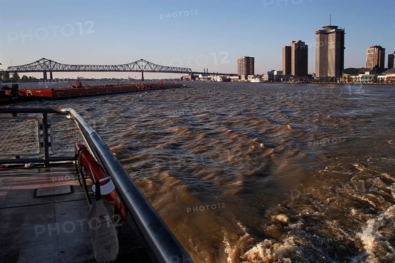 View of Mississippi River with skyscrapers and bridge at sunset, New Orleans, Louisiana, USA