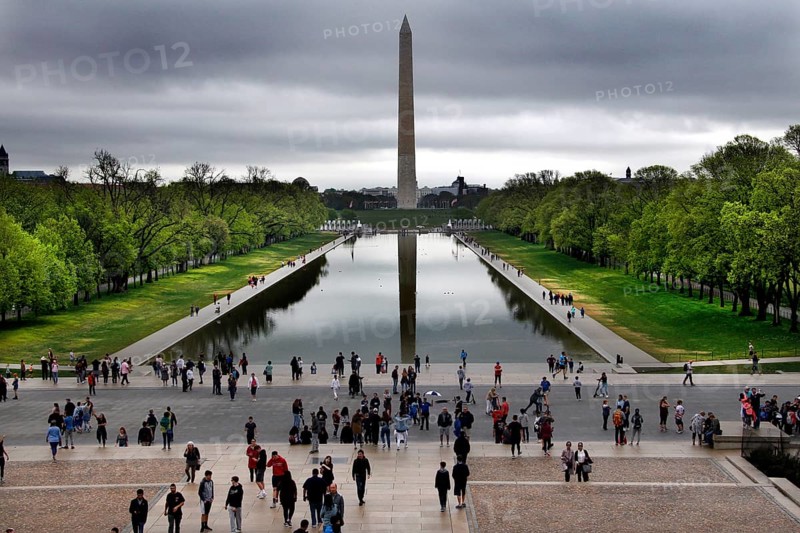 Visitors look at the Washington Monument across a reflecting pond, Washington D.C, USA