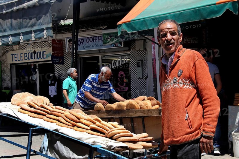 A bread seller presents his goods on the lively Place Mohammed VI in Moulay Idris, Moulay Idris, Fès-Meknès, Morocco