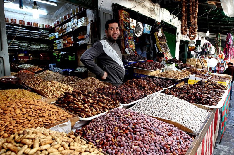 A vendor at a market stand offers a wide range of dates and dried fruits, Tetouan, Medina, Morocco