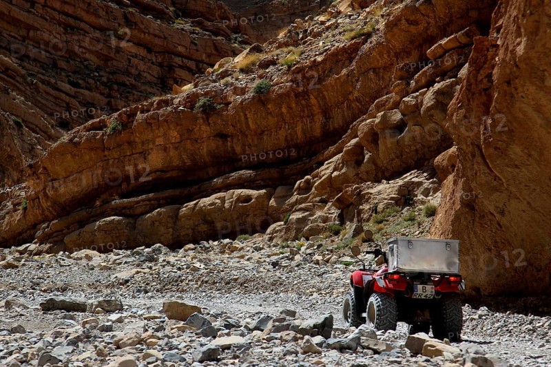 A quad bike surrounded by rocky cliffs in the gorge landscape, Tal, Tizgui n'Ouadda