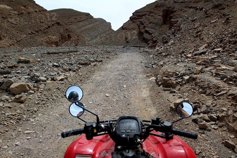 View from a motorcycle of a narrow, rocky path in a gorge, Tizgui n'Ouadda, Morocco