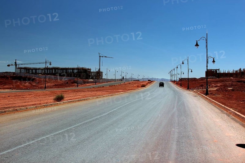 Lonely road with lanterns in dry desert environment under clear sky, Tinerhir, Morocco
