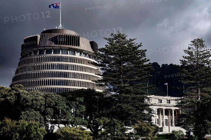 The parliament building 'Beehive' in Wellington surrounded by trees under a cloudy sky, Wellington, New Zealand