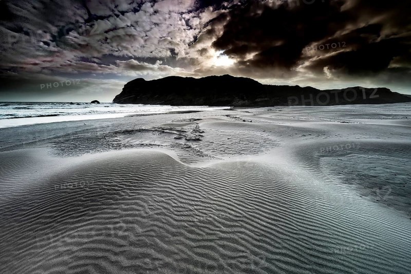 Rough sand dunes on Wharariki Beach in dramatic skies at dusk, zero