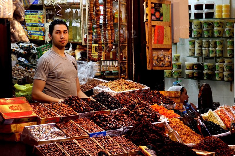 A retailer offers a variety of dried fruits at a busy market, Fez, Fez el Bali, Morocco