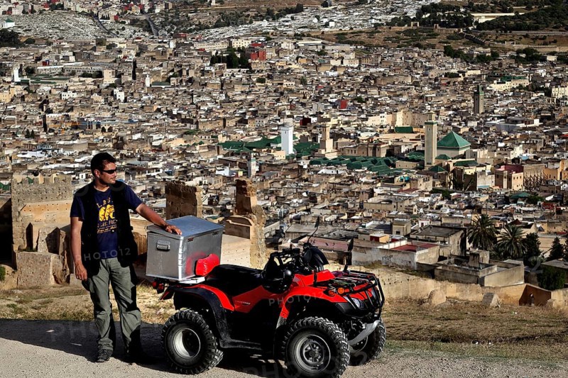 Man with quad bike in view of Fez from the Merinid Tombs, Fez, Fez el Bali, Morocco