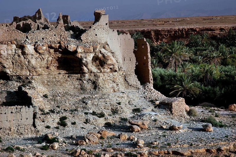 Dilapidated kasbah overlooking green vegetation and barren surroundings, Meski, Morocco