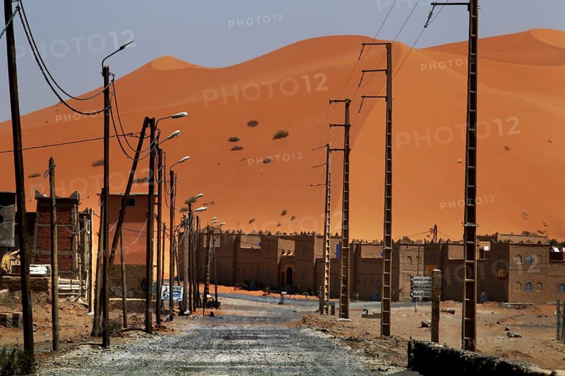 Dunes on the horizon behind the modern settlement of Merzouga, Merzouga, Niger, Morocco
