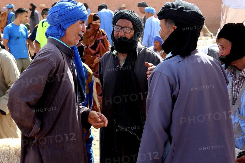 Three men in traditional clothing talking at a cattle market, Guelmim, Guelmim-Oued Noun, Morocco