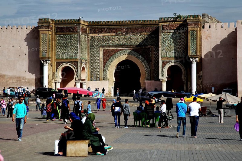 Large decorated gate in a public square, with people gathering, Meknes, Fès-Meknes, Morocco