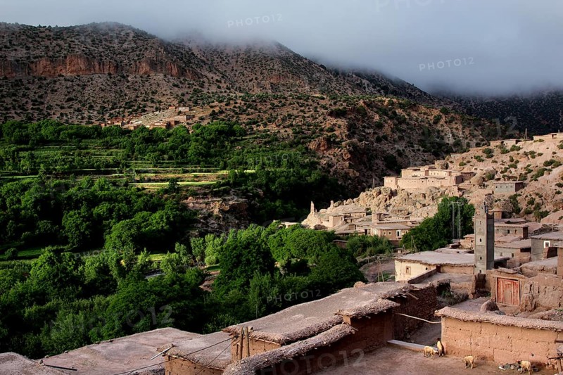 View of a traditional village in the valley surrounded by green hills of the High Atlas Mountains, Ait Bou Goumez, High Atlas, Morocco