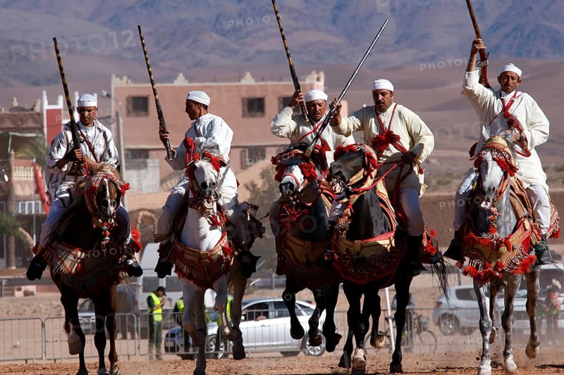 Riders riding decorated horses in an impressive formation at Fantasia, El Kelâa m'Gouna, Morocco