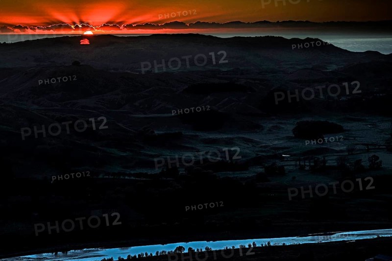 Dramatic sunrise behind mountain landscape with intense colors, Te Mata Peak, New Zealand