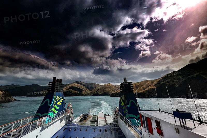 View of clouds and mountains on water from the stern of a ferry, Queen Charlotte Sound, Marlborough, New Zealand