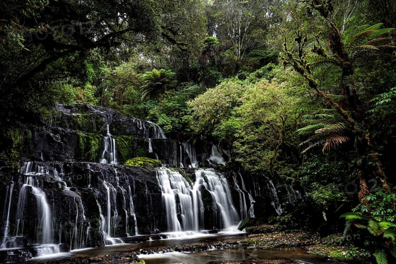 Idyllic waterfall nestled in a green jungle landscape, Purakaunui Falls, New Zealand