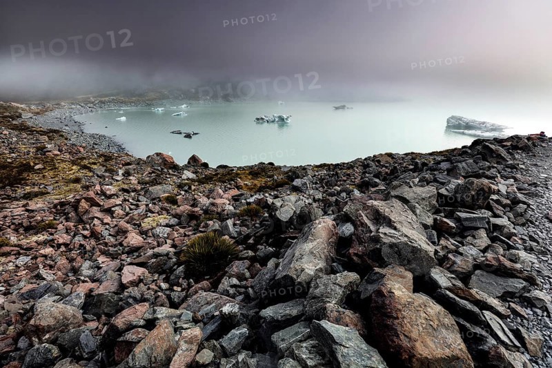 Cold glacial lake on Hocker Valley Track with rugged rocks and fog, Mt Cook, Hocker Valley Track, New Zealand