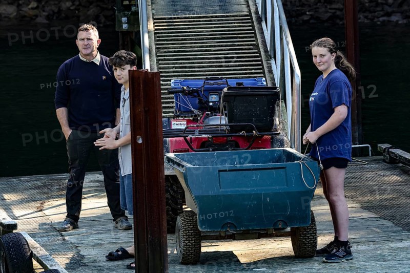 Group of people load luggage on a pier at Pelorus Mailrun