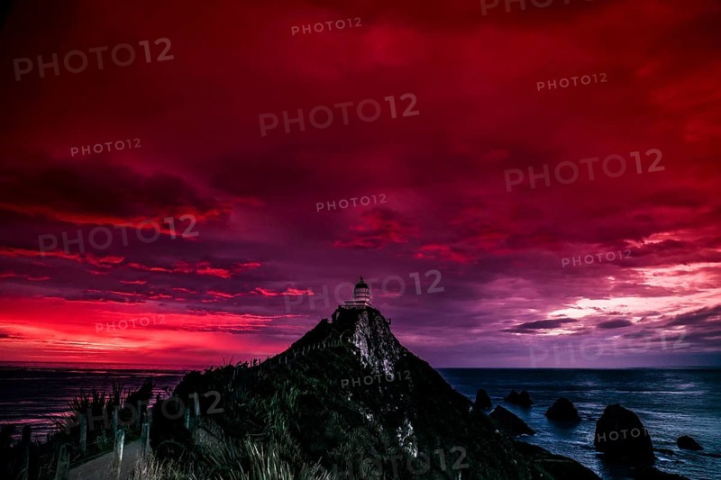 Lighthouse on Nugget Point under a dramatic red sunrise sky, Nugget Point, Otago, New Zealand