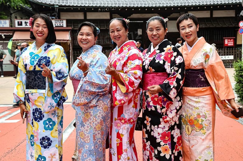 Group of woman wearing colorful kimonos against a traditional backdrop in Tokyo, Tokyo, Asakusa, Japan