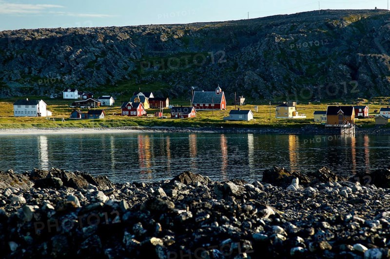 View of Hamningberg with kittiwakes along the coast and reflections in the water