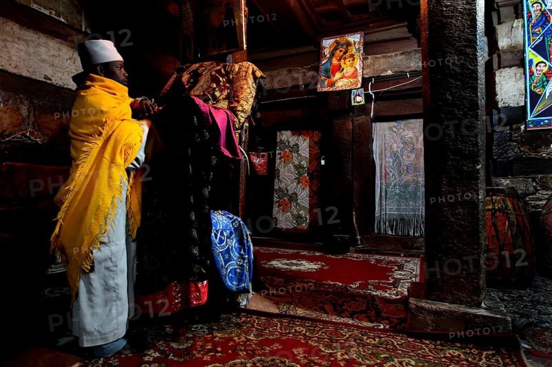 Two men in traditional robes in the richly decorated monastery church, Debre Damo, Tigray, Ethiopia
