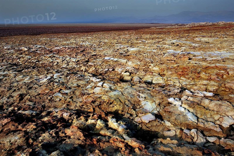 Wide, barren rocky landscape under barren sky in Dallol, zero