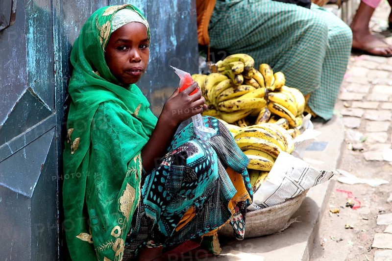 Child banana saleswoman wearing traditional clothes in the old town of Harar, Harar, null