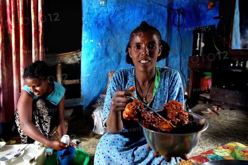 Woman having fun presenting a dish to Chuchu's family in Lalibela, Lalibela, null