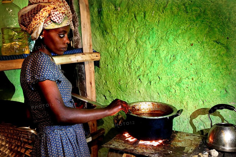 Woman carefully cooks chicken in rural kitchen, Lalibela, Ethiopia