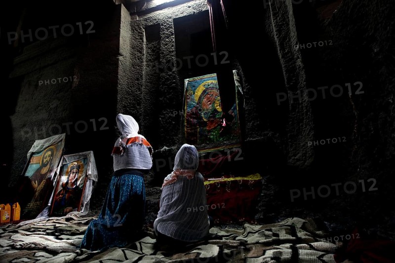 People praying in front of icons in Bete Medhane Alem, Lalibela, Amhara, Ethiopia