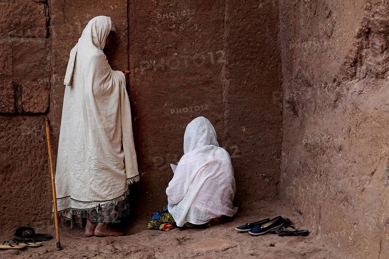 Women in white scarves praying on a church wall during Easter, Lalibela, Amhara, Ethiopia