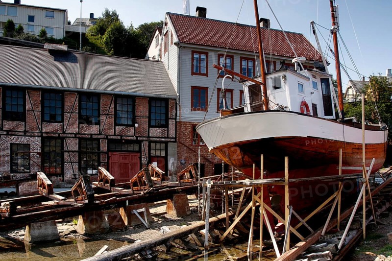 Mellemværftet shipyard on Kirkelandet with historic houses and ship, Kristiansund, Møre og Romsdal, Norway