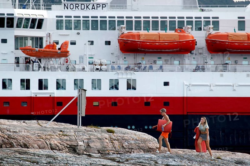 Hurtigruten ship in Kristiansund, dock with passengers and distinctive red lifeboats, Kristiansund, Norway