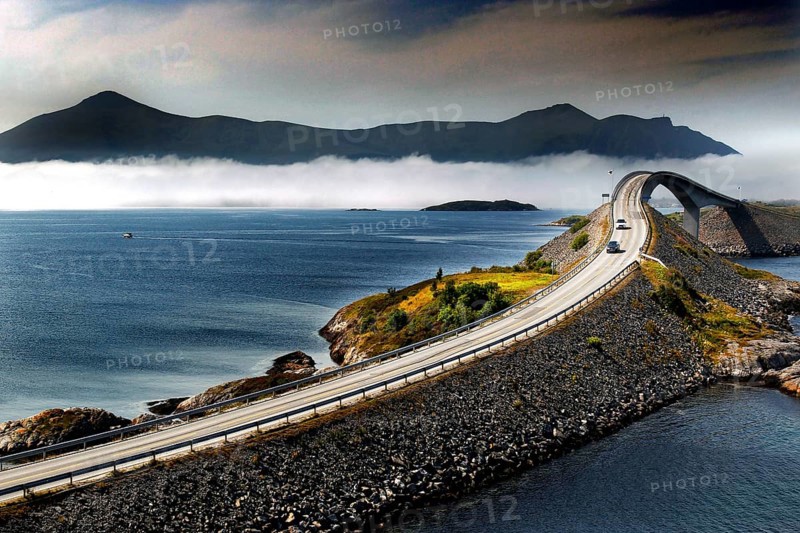 Spectacular view of the winding road across the Atlantic road with surrounding mountains and clouds, N Lauvøyford, Norway