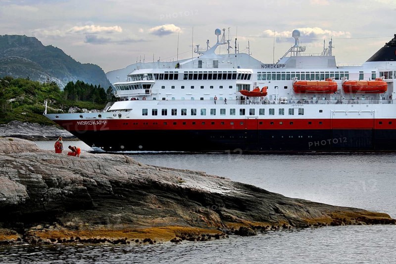 Hurtigruten ship near rocks and mountains on open sea, Kristiansund, Møre og Romsdal, Norway