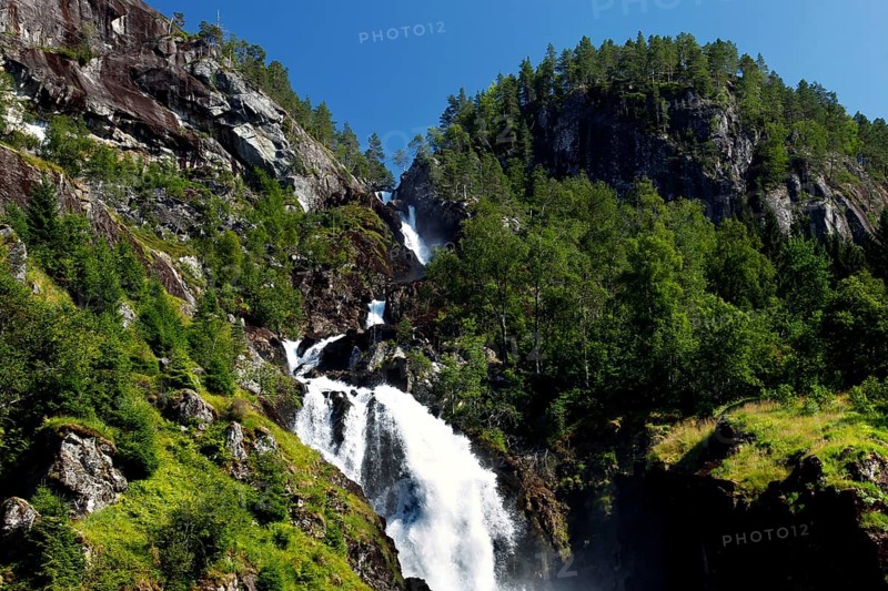 Impressive Låtefossen waterfall with steep rocks in the background and lush vegetation, zero