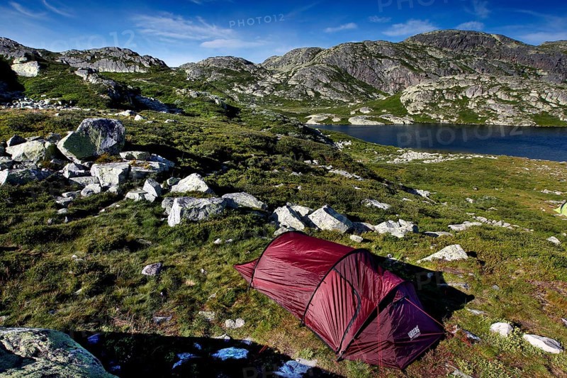 Red tent in mountainous seascape surrounded by untouched nature, Hardangervidda, Gausdal, Norway