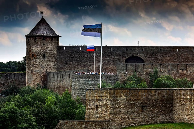 Close-up of Hermann Fortress with Estonian and Russian flags including dramatic clouds, Narva, Estonia