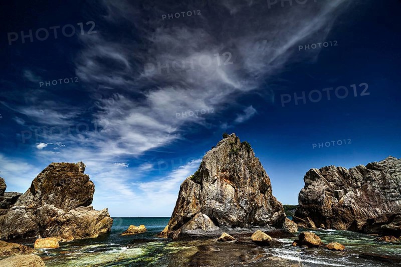 Impressive rock formations rise on the coast under a dramatic sky, Kushimoto, Wakayama, Japan
