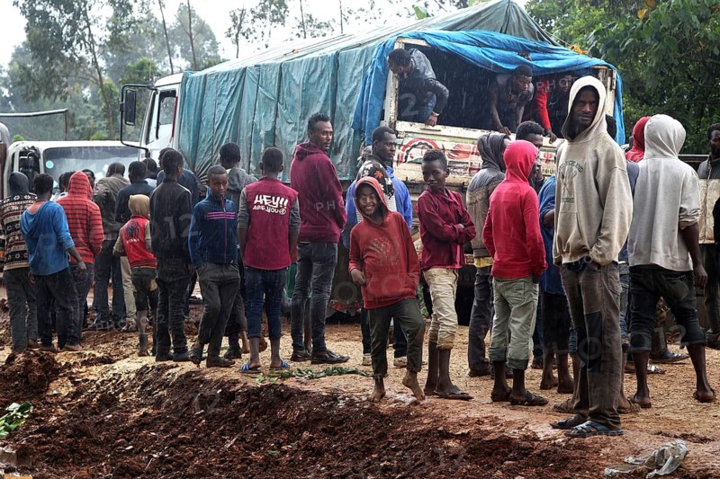 Group of people gather around a truck on a muddy road, Yirga Alem, Yabello, Ethiopia